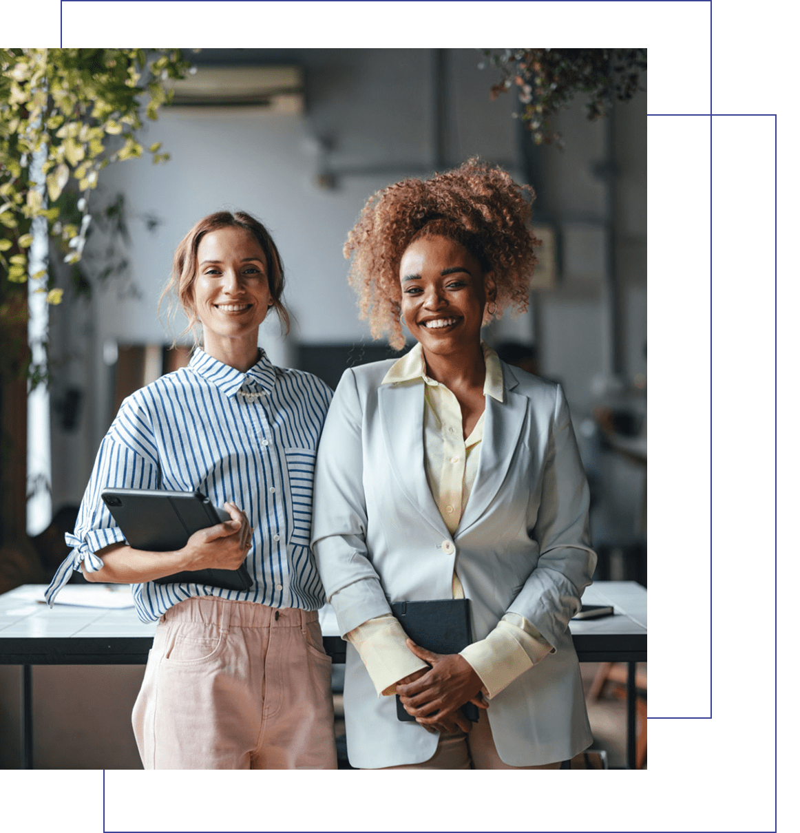 Two women smiling in a modern office.